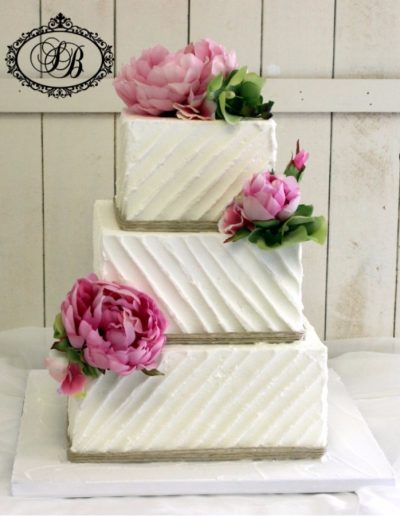 Square royal iced wedding cake with silk peonies