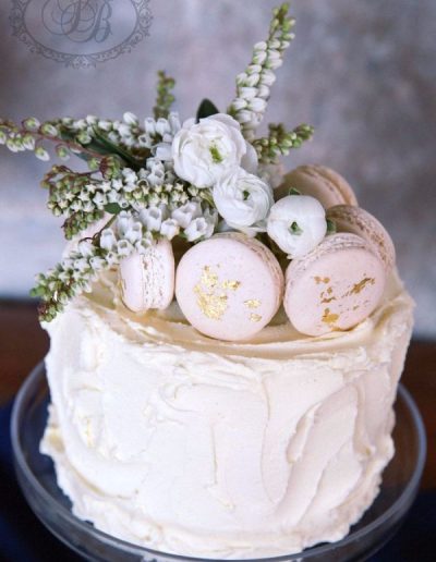 Buttercream wedding cake with macarons and fresh flowers