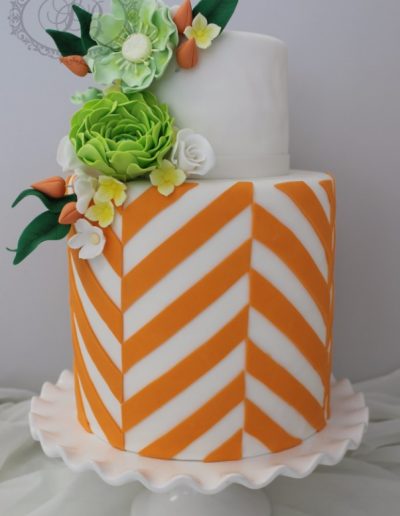 Orange diagonal stripe wedding cake with green sugar flowers