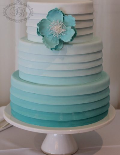 Teal blue stripe wrap wedding cake with sugar flower