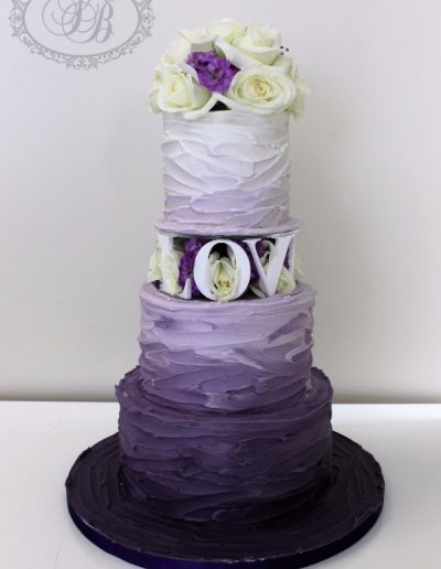 Purple ombre royal iced wedding cake with fresh flower blocking