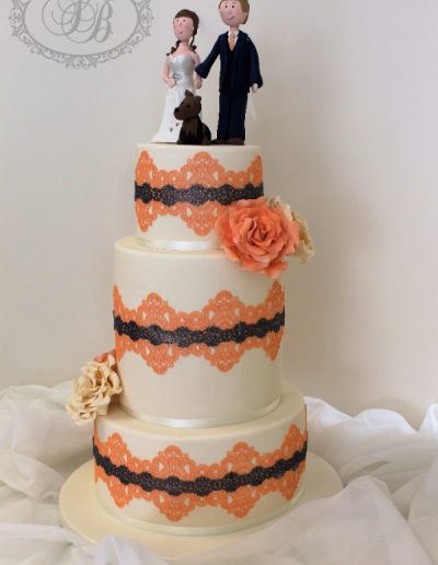 Peach and grey lace wrap wedding cake with couple topper