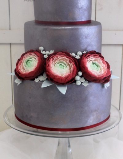 Silver airbrushed wedding cake with maroon ranunculus