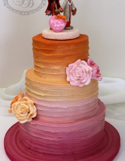 Pink to orange ombre ganache wedding cake with sugar roses