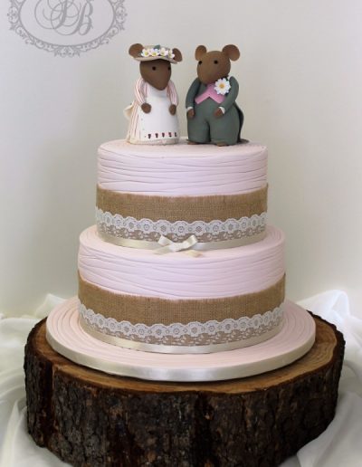 Pastel pink scribed wedding cake with hessian, lace and mice toppers