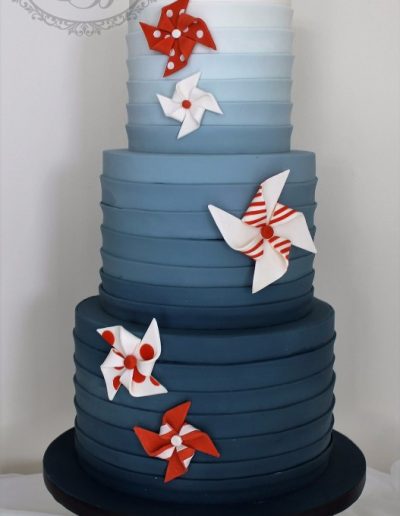 Teal blue stripe wrap wedding cake with orange pinwheels