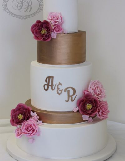 5 tier wedding cake with copper monogram and pink sugar flowers