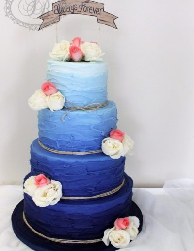 Dark blue ombre royal iced wedding cake with fresh flowers