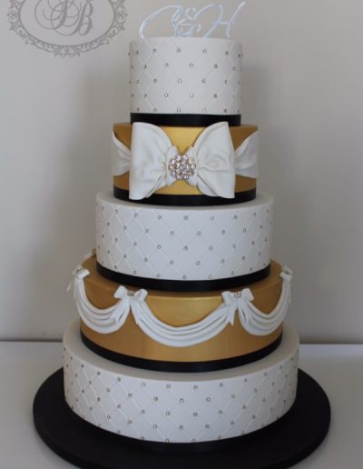 5 tier wedding cake with quilting, gold and sugar bows