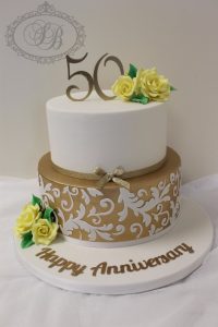 2 tier 50th birthday cake with gold and yellow flowers