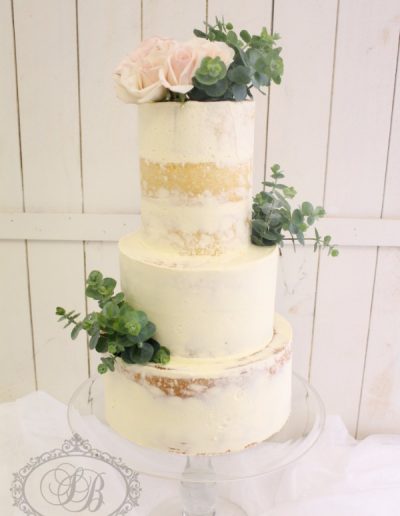 3 tier naked buttercream cake with greenery and roses