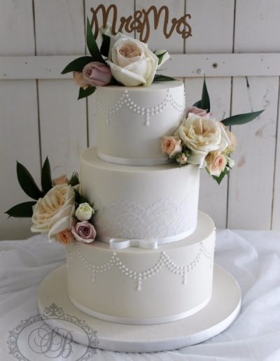 3 tier ivory wedding cake with lace and fresh flowers