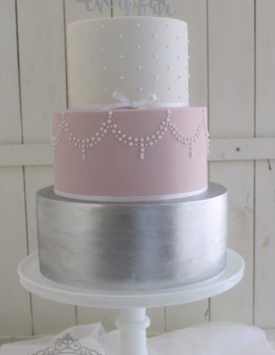 Pink, silver and white wedding cake with topper