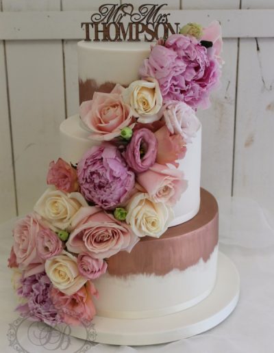 Copper paint fade wedding cake with fresh flower cascade