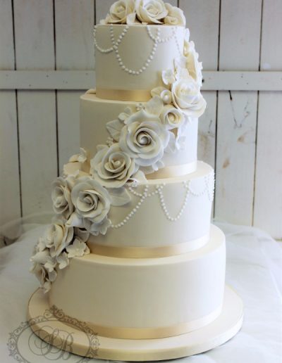 Light gold wedding cake with pearl strand piping and sugar flower cascade