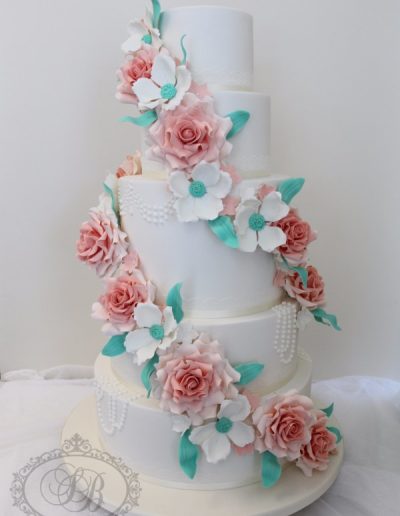 5 tier pearl piped wedding cake with full teal and peach sugar flower cascade