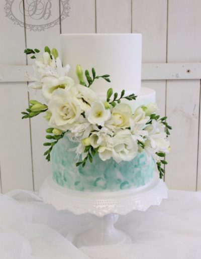 Teal sponged paint wedding cake with fresh flowers