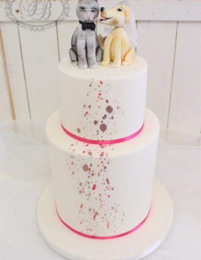 Pink and silver paint splash wedding cake with animal toppers