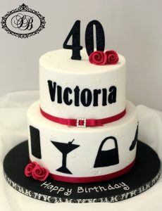2 tier white and black cake with silhouettes and pink flowers