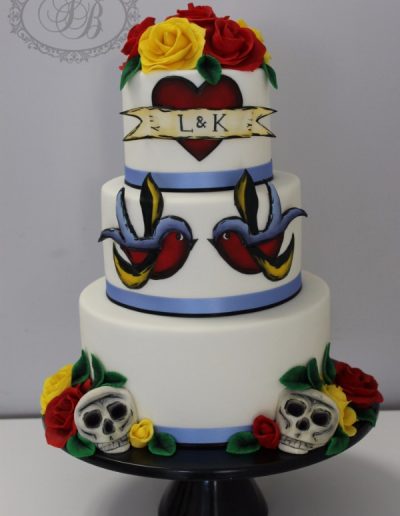 3 tier colourful wedding cake with skulls, flowers and swallows