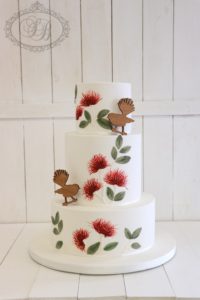 3 tier white wedding cake with pohutukawa flowers