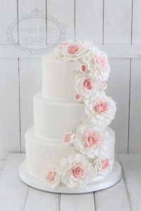 Simple white wedding cake with ombre rose cascade